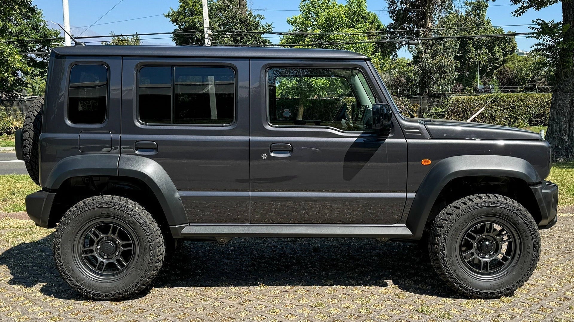 5-door Suzuki Jimny (2023+) with Matte Dark Gunmetallic Enkei Allroad RPT1 Wheels and other accessories.
