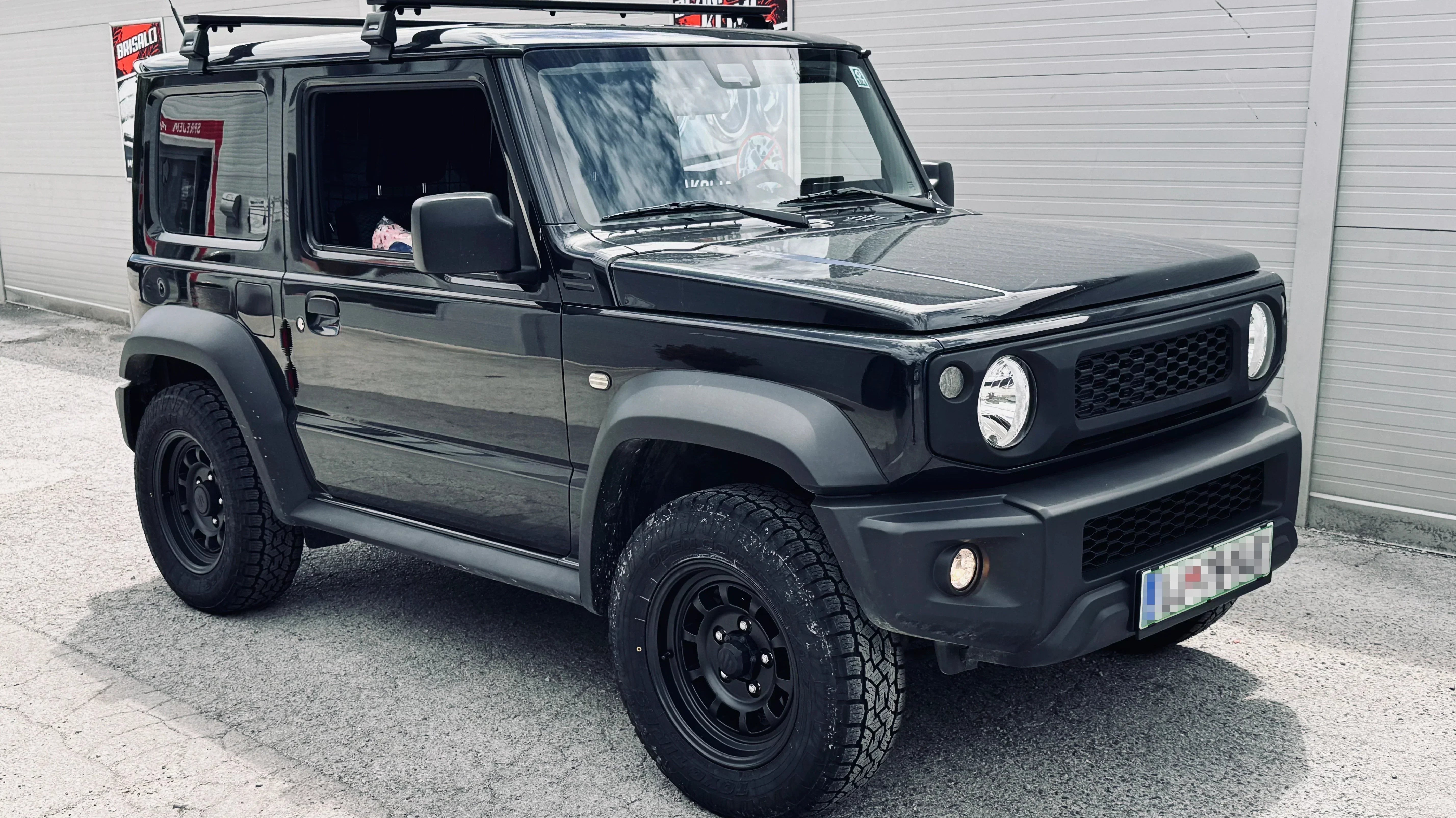 Black Suzuki Jimny (2018+) with Matte Black High Peak J-01 wheels and Retro Front Grille