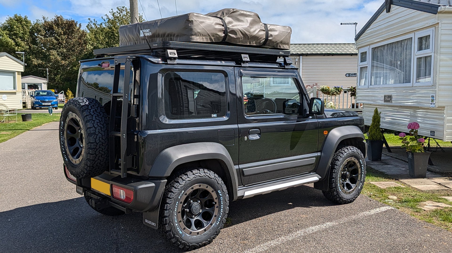 Suzuki Jimny 2018+ with XTREME-J XJ03 Wheels and a Front Runner Roof Rack, Rear Ladder and Roof Tent.