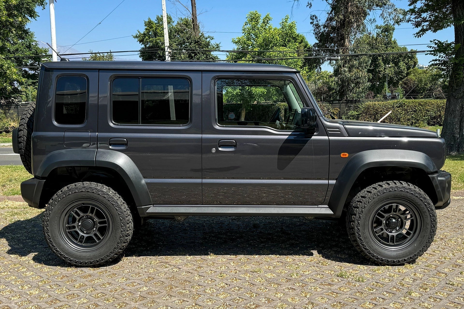 5-door Suzuki Jimny (2023+) with Matte Dark Gunmetallic Enkei Allroad RPT1 Wheels and other accessories.